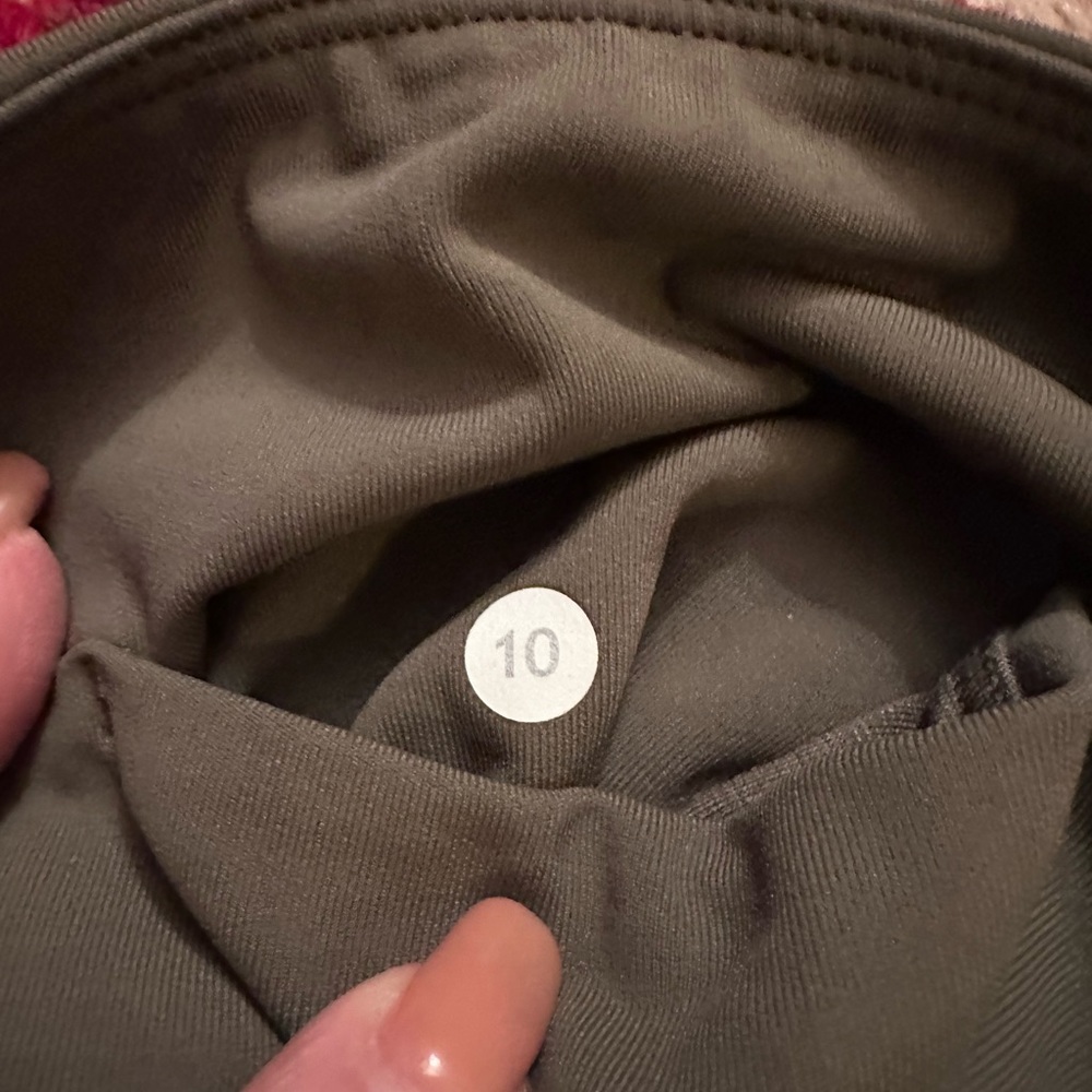Lululemon sage green yoga leggings with cute mesh detailing at ankles.